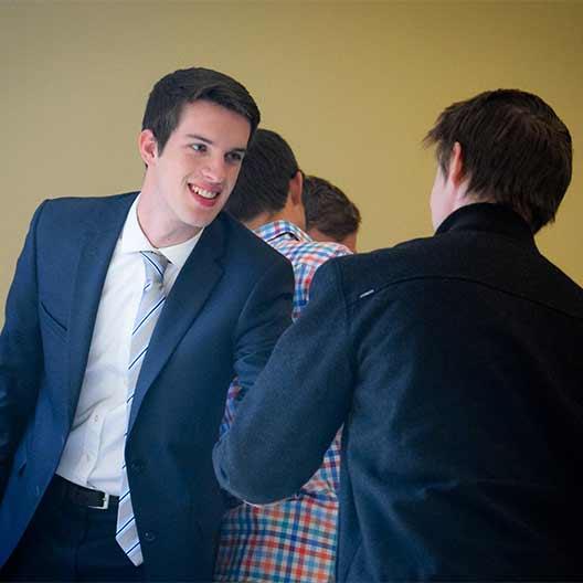 Two business students shaking hands